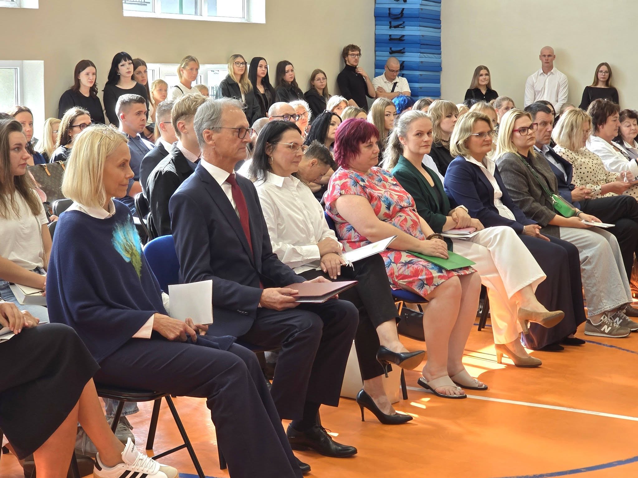Zdjęcie grupowe nauczycieli i dyrekcji podczas rozpoczęcia na Hali Sportowej.