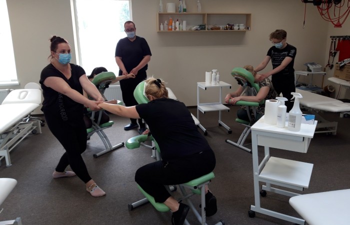 wykonywania masarzu osoby przez technika na krześle do masarzu 