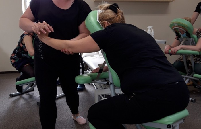 wykonywania masarzu osoby przez technika na krześle do masarzu 