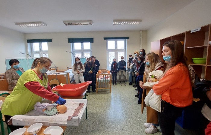 osoby oglądające  przewijanie dziecka - manekina