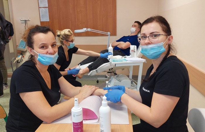 dwie panie w maseczkach podczas malowania paznokci