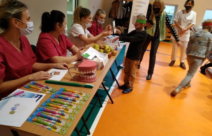 Dzieci na hali sportowej uczą się dbania o zęby i jamę ustną.