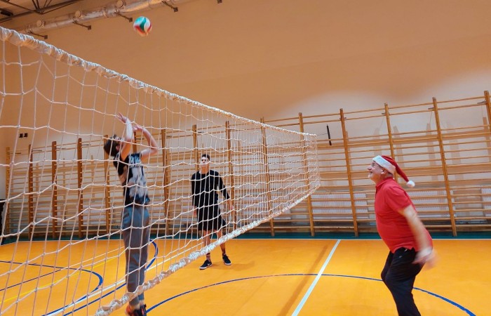 Uczniowie grający w siatkę na hali sportowej