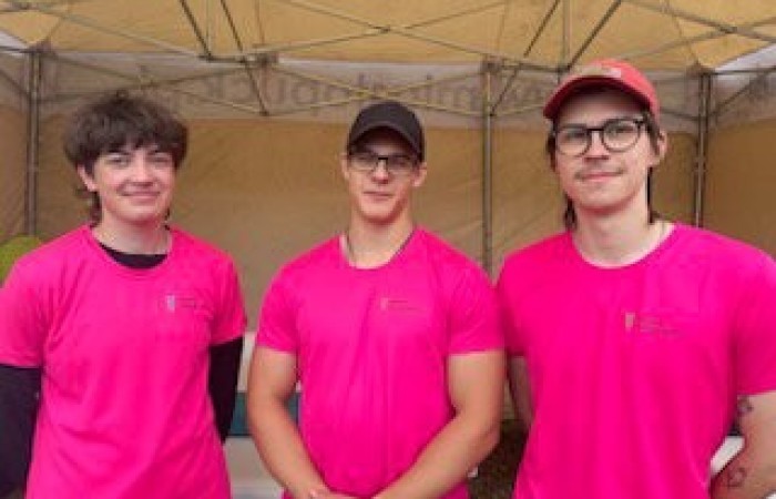 Trzech uczniów szkoły w różowych koszulach.