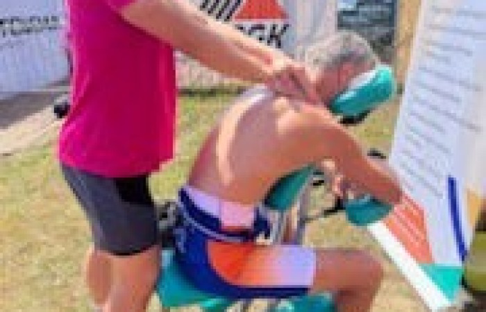 Uczeń wykonujący masaż pleców uczestnika zawodów.