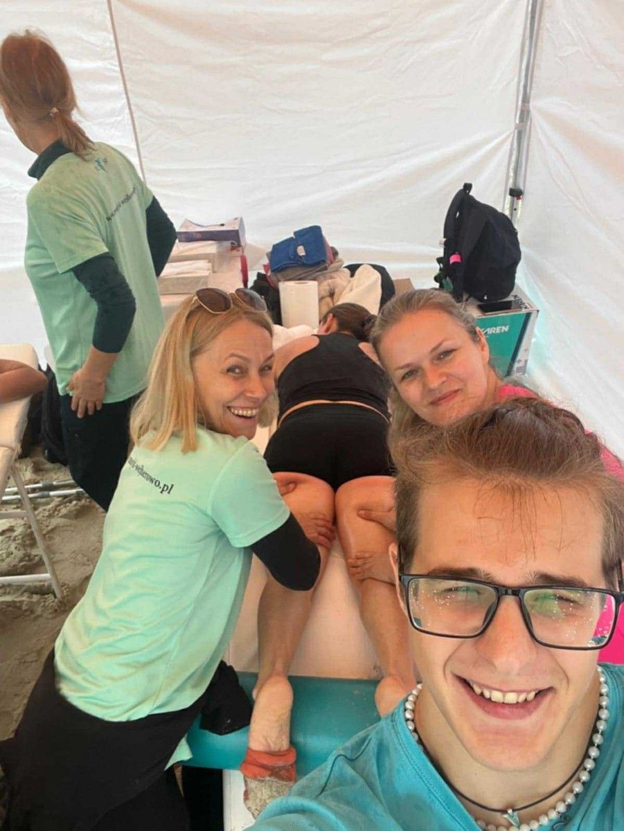 Masaż nóg na stole do masażu przez uczniów uczestnika maratonu.