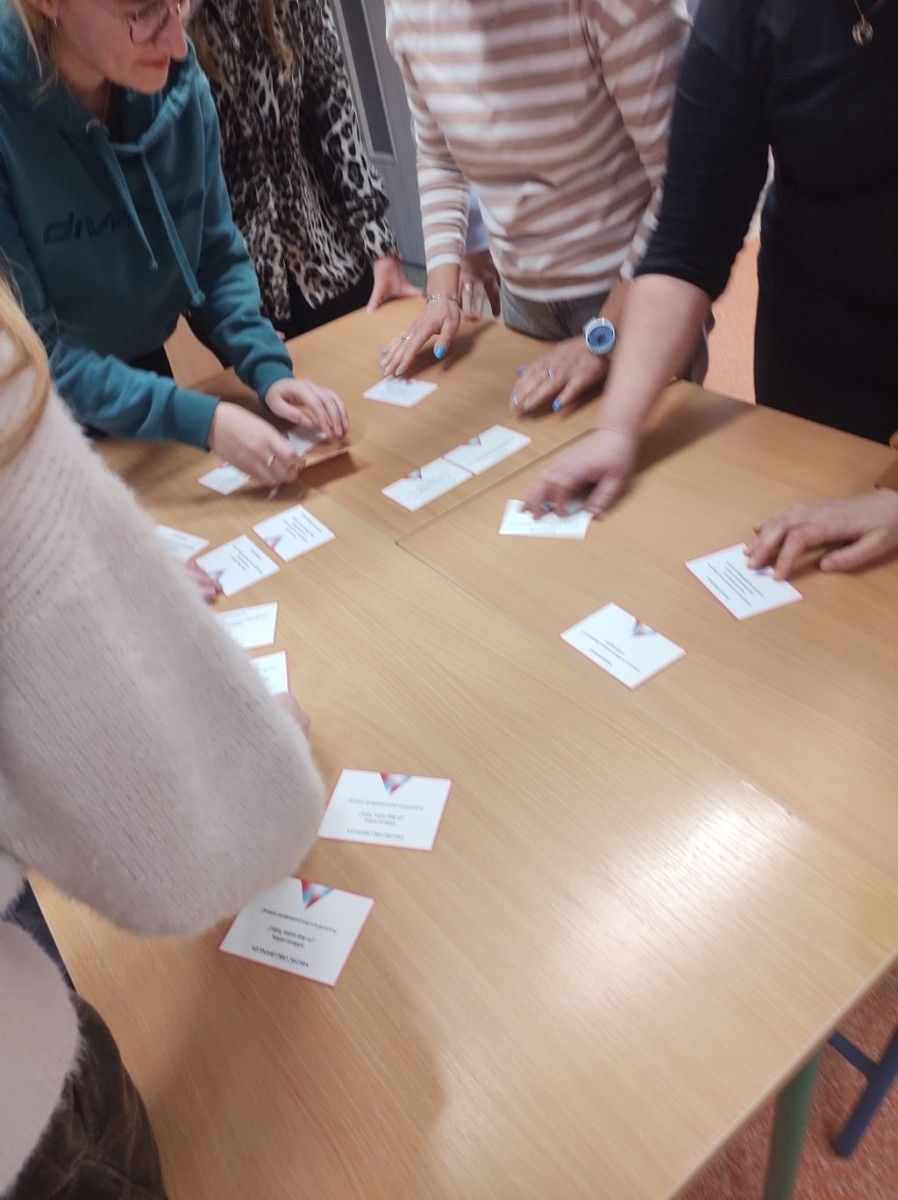 Uczniowie pracujący w grupach przy stole.