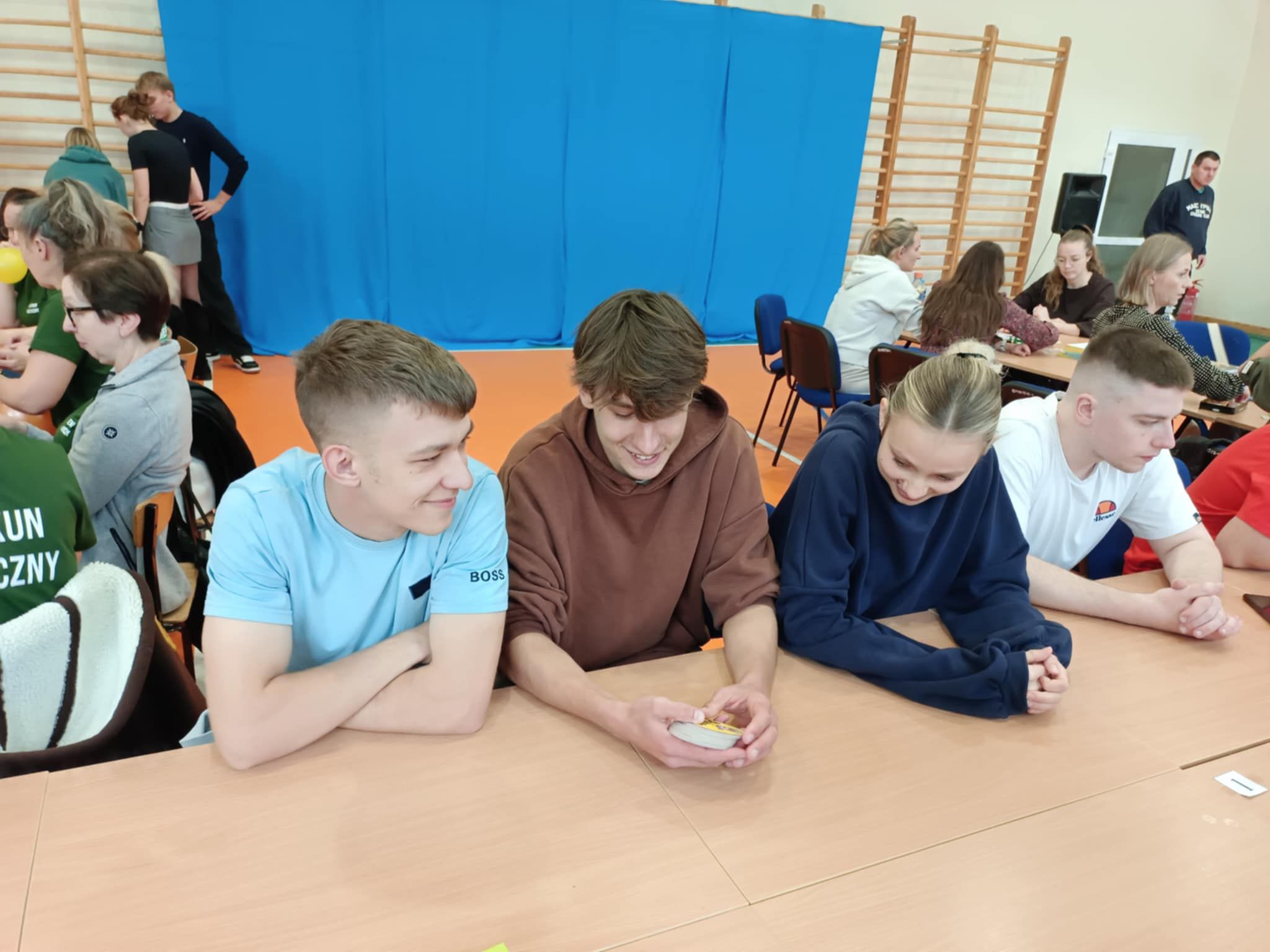 Zdjęcie grupowe słuchaczy przy stołach.