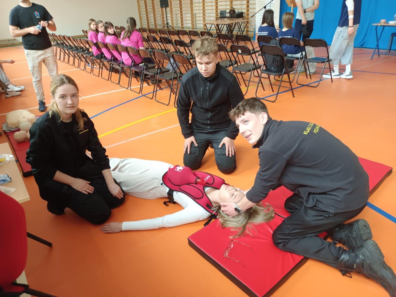 Uczestnicy ratujący omdloną osobe.