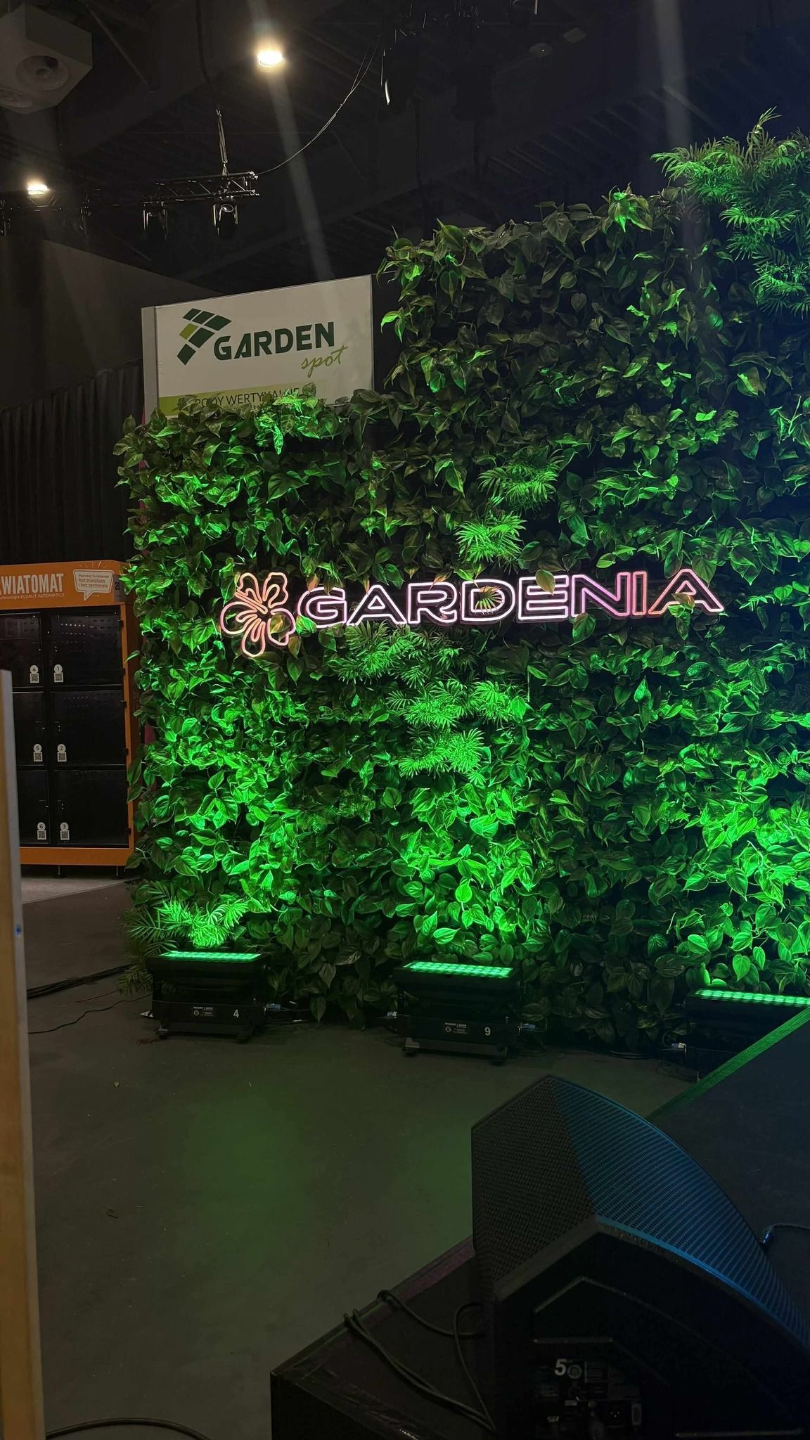 Widok na zieloną ścianę z kwiatów z neonem.