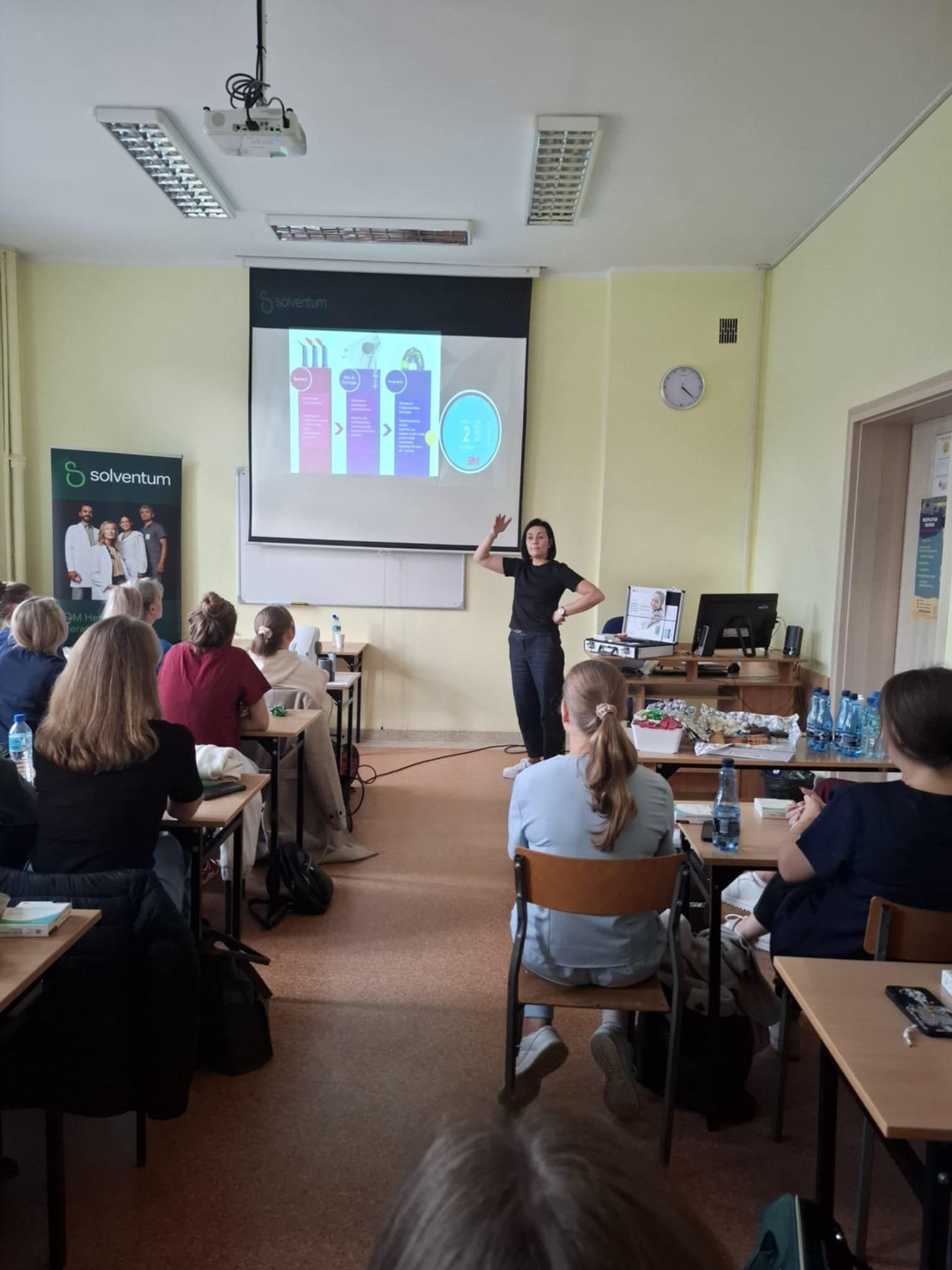 Widok na salę z uczniami oglądającymi prezentację.